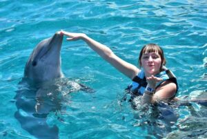 niña nadando con delfines en isla mujeres